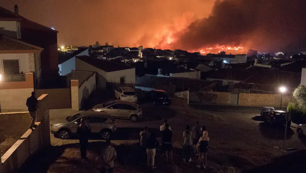 Vecinos de Zalamea la Real observan las llamas del incendio que desde el pasado jueves afecta a la sierra de Huelva