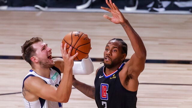 Luka Doncic intenta sortear la defensa de Kawhi Leonard