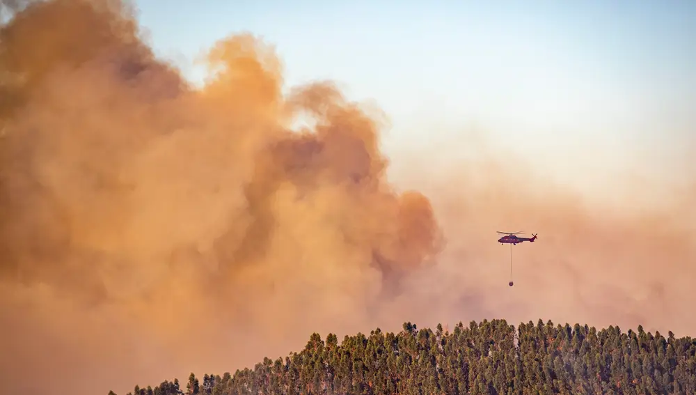 Un helicóptero descarga sobre la sierra onubense para intentar sofocar el fuego