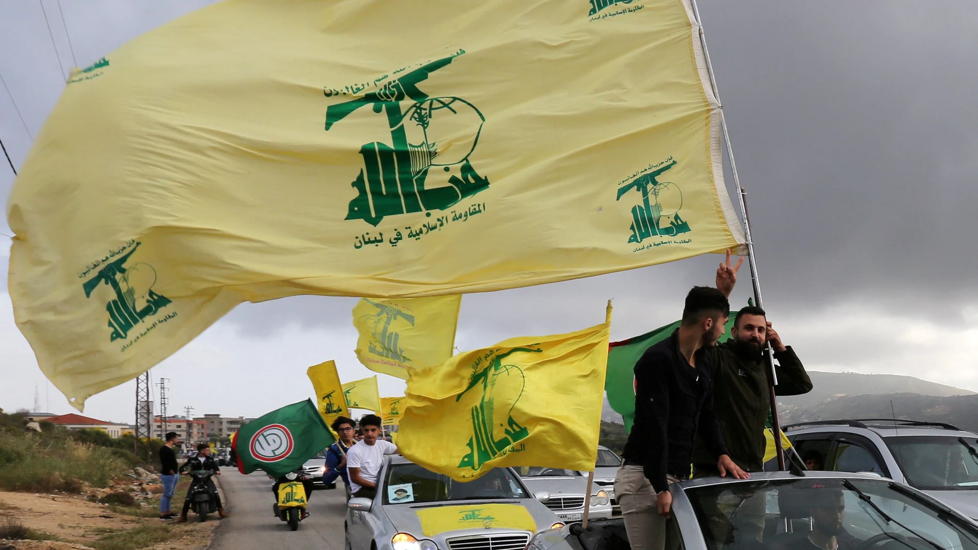 FILE PHOTO: A supporter of Lebanon's Hezbollah gestures as he holds a Hezbollah flag in Marjayoun