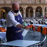 Un camarero trabaja en la terraza de un restaurante de la plaza mayor de Salamanca