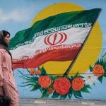 Una mujer camina frente a un mural con la bandera de Irán situado en una de las calles de Teherán.ROUZBEH FOULADI / ZUMA PRESS / C02/09/2020