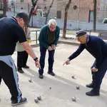 Varios jubilados juegan a la petanca en un parque del centro de Madrid