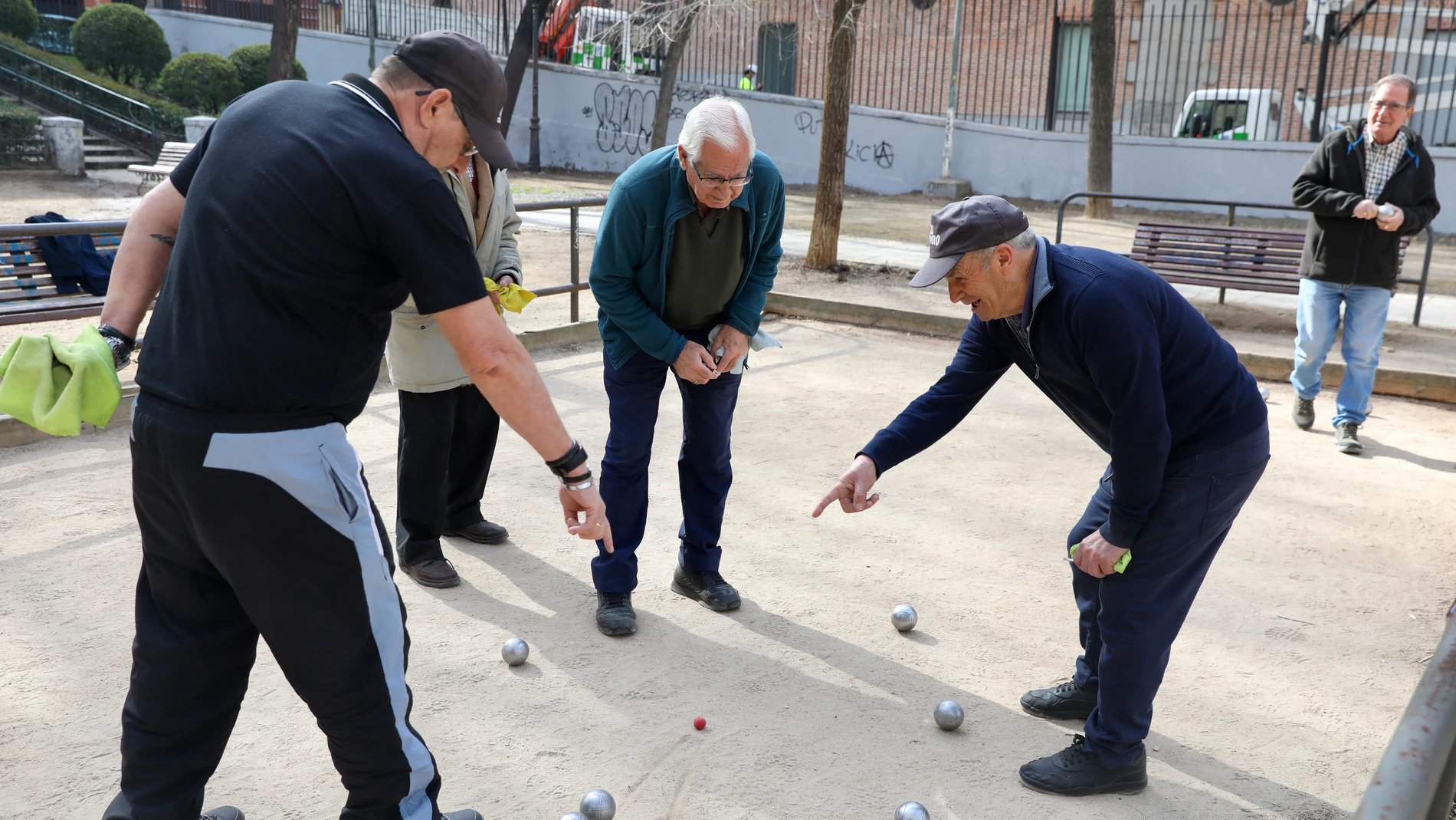 Varios jubilados juegan a la petanca en un parque del centro de Madrid