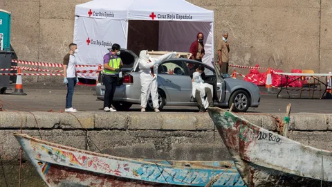 Varias personasobservan este jueves los barcos confiscados en el muelle de Arguineguín, Gran Canaria, donde esperan ubicación más de 150 inmigrantes. Canarias recibió en los ocho primeros meses del año 3.933 inmigrantes llegados a sus costas o rescatados en aguas de su entorno en 136 pateras o cayucos, casi siete veces más que en el mismo período de 2019 (3.349 más, +573,5 %), según datos del Ministerio del Interior a 31 de agosto. EFE/ Quique Curbelo