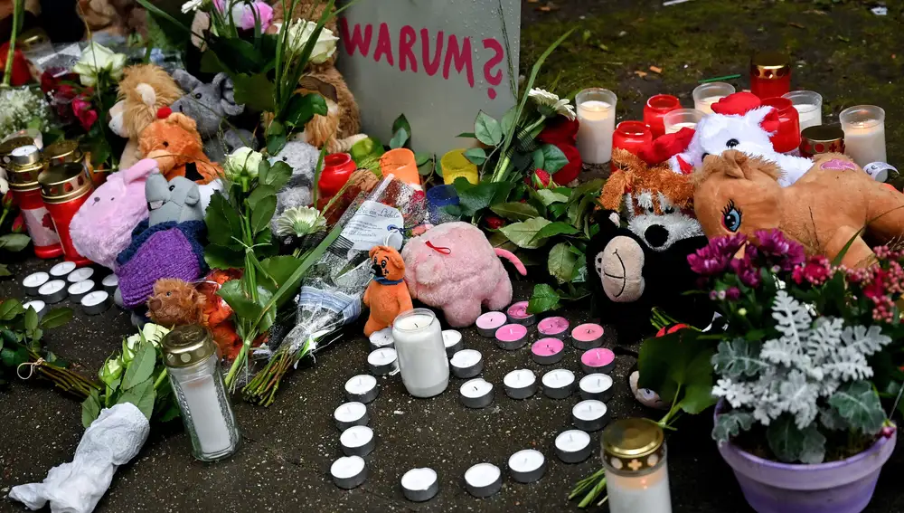 Flores, velas y peluches se han ido depositando esta mañana en el edificio en el que ayer aparecieron cinco hermanos asesinados por su madre, según la acusación de la fiscalía alemana