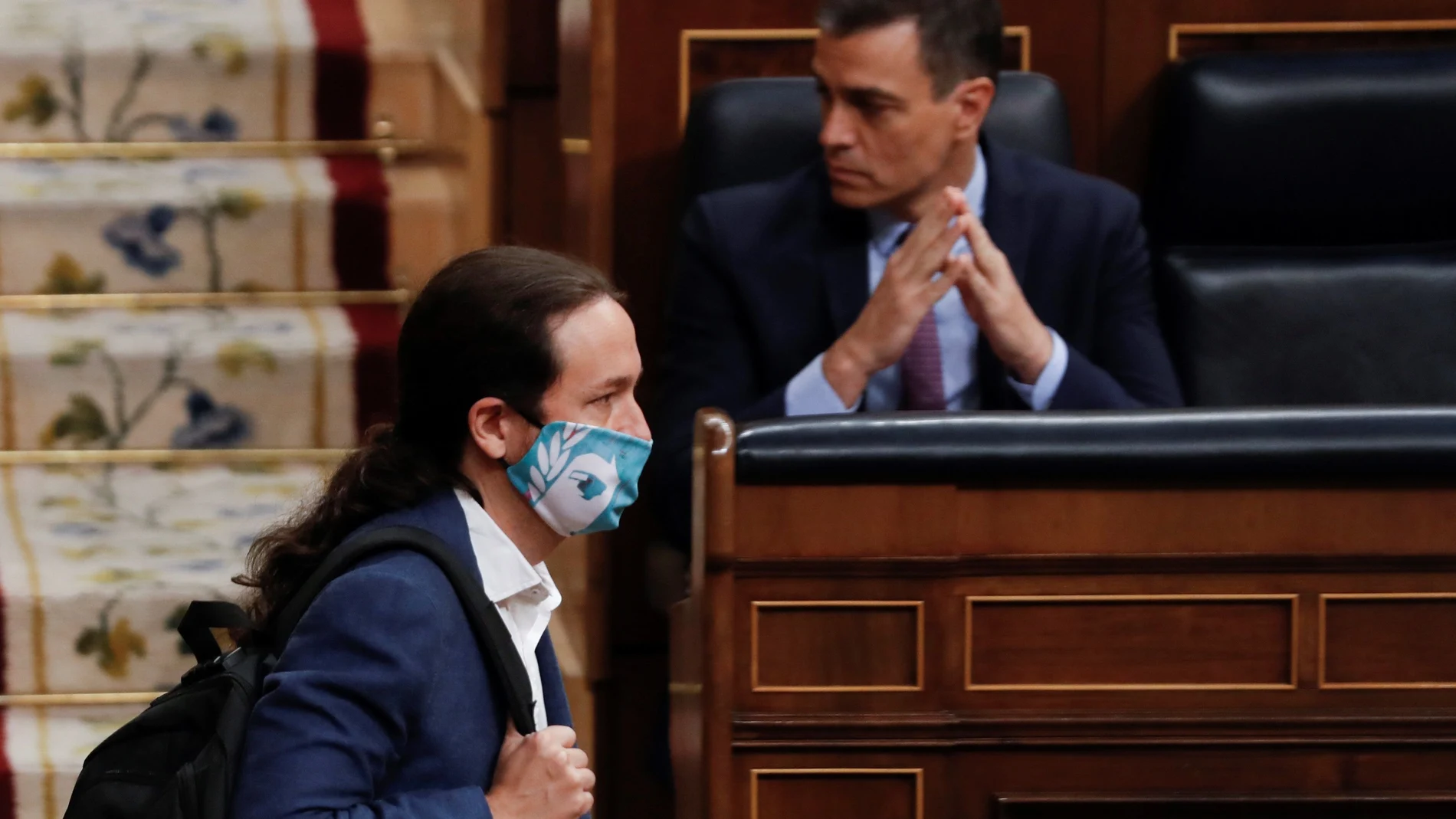 El vicepresidente segundo del Gobierno, Pablo Iglesias, pasa delante del presidente Pedro Sánchez en el Congreso de los Diputados