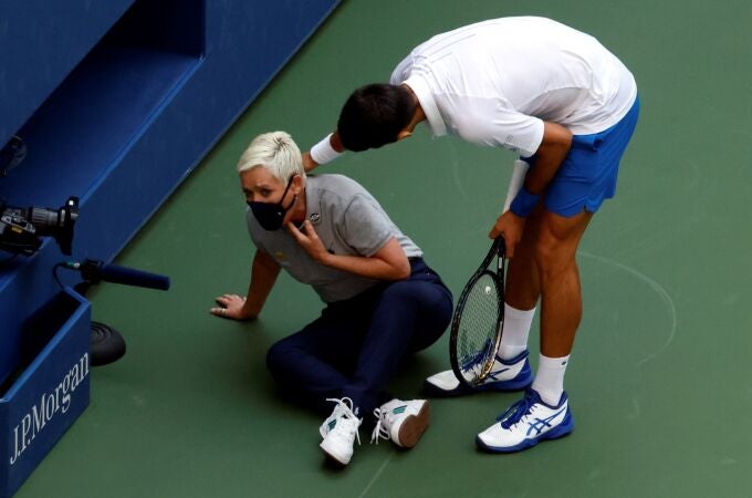 Novak Djokovic atiende a la juez de línea después del pelotazo.