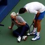 Novak Djokovic atiende a la juez de línea después del pelotazo.