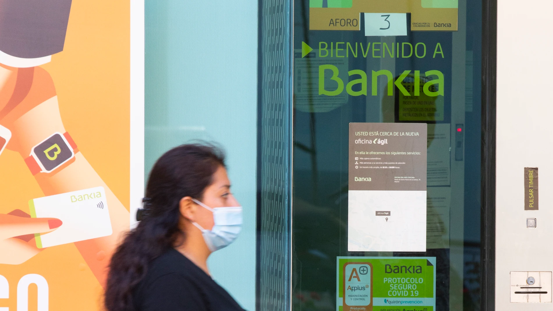 Imágenes de una sucursal bancaria de Bankia en la que se ve de fondo una de La Caixa