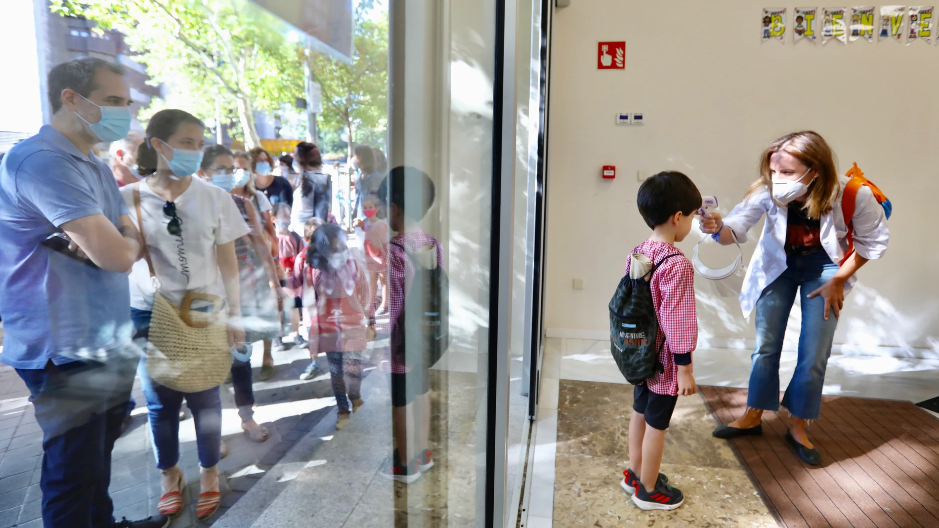 Una profesora toma la temperatura a un alumno en su primer día de clase en el colegio Claret de Madrid