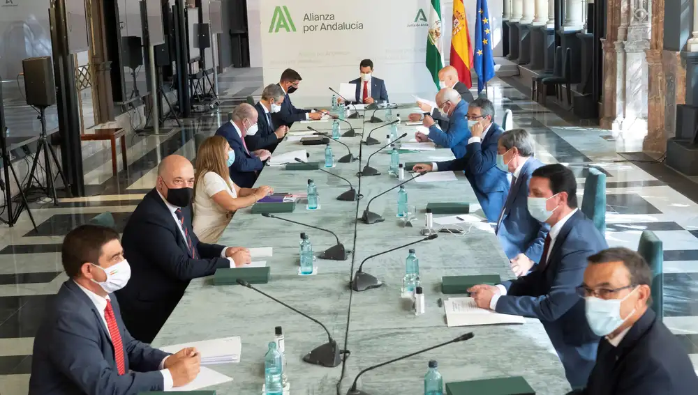 El presidente de la Junta de Andalucía, Juanma Moreno (al fondo), presidiendo esta tarde la reunión mantenida con los presidentes de las diputaciones provinciales