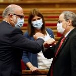 El presidente de la Generalitat, Quim Torra, saluda al portavoz de JxCat, Eduard Pujol (i), a su llegada al Parlament.