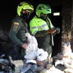 Oficiales observan los restos incinerados del Centro de Atención Inmediata (CAI) La Gaitana de la Policía en la localidad de Suba, en Bogotá (Colombia).