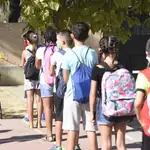 Alumnos de un colegio de Sevilla hacen cola ante una profesora