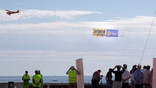 Una avioneta porta una lona donde se lee “Aturem la decadència” (paremos la decadencia) sobre las playas de Barcelona es el mensaje que Societat Civil Catalana ha emitido en esta Diada Nacional en Cataluña.