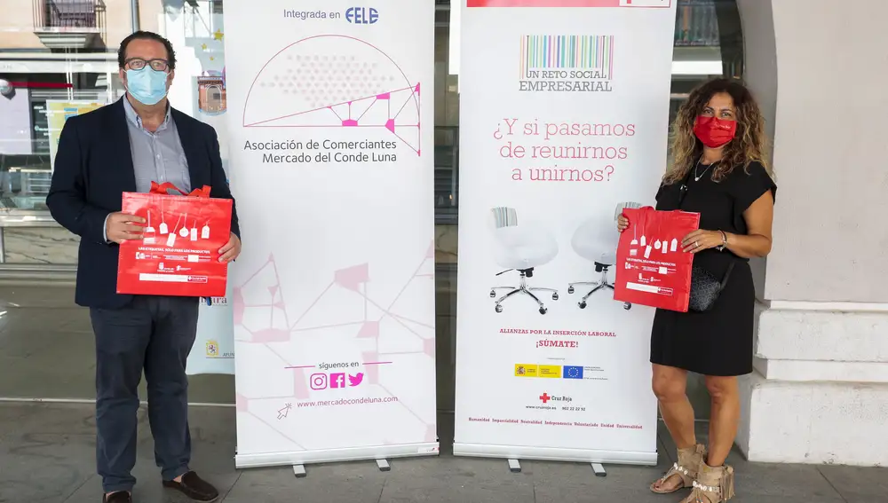 La directora provincial de Empleo de Cruz Roja Española en León y el representante de la asociación de comerciantes del Mercado del Conde Luna, Ramón Polanco, presentan la campaña ‘Las etiquetas, sólo para los productos’