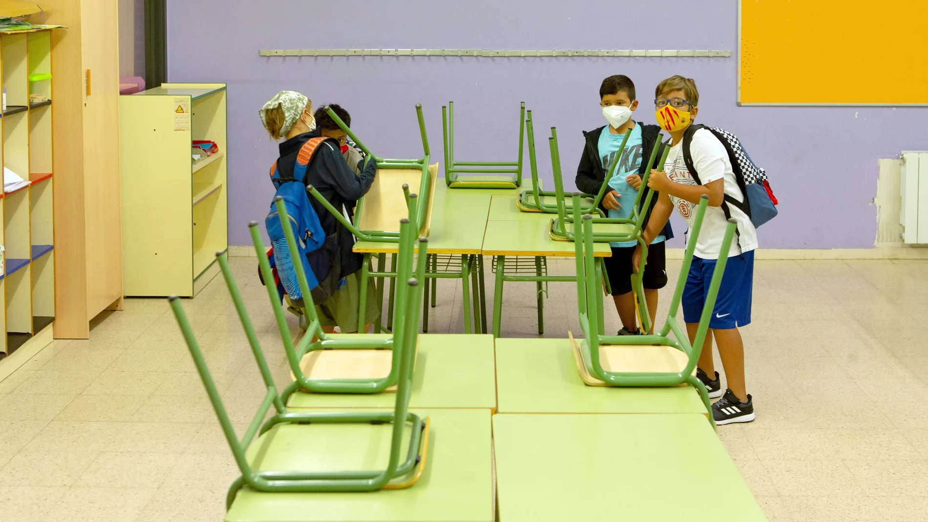 Varios niños llegan a su aula de la Escola Catalonia de Barcelona.