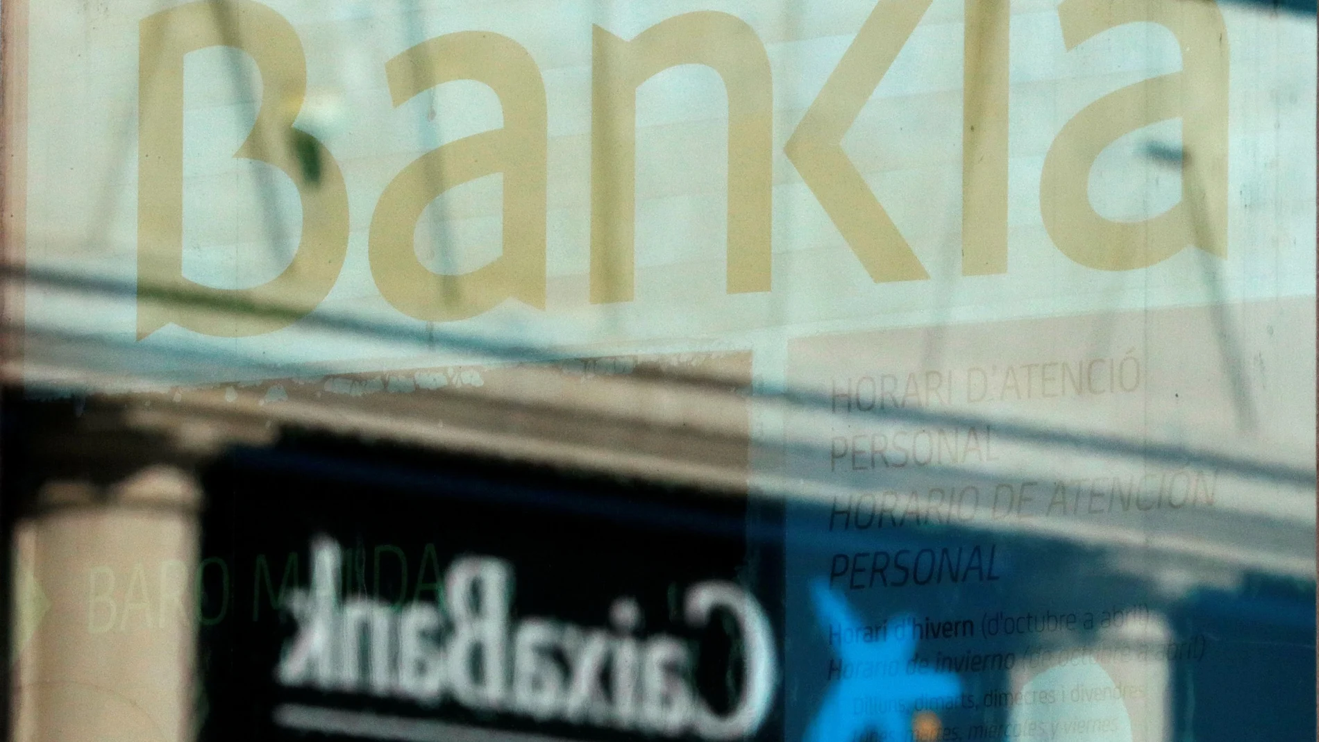 Logos of Caixabank and Bankia's are seen in bank offices near Barcelona
