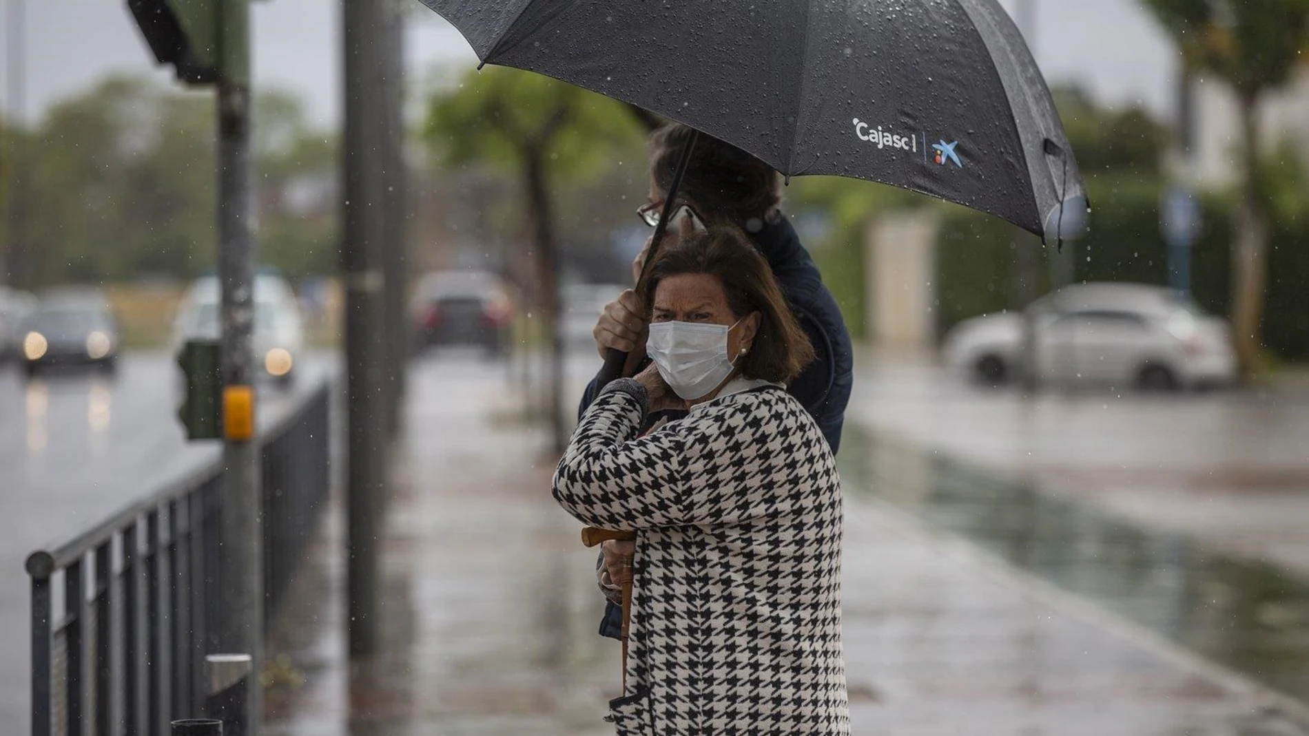 Dos personas sujetan un paraguas durante una tormenta