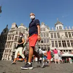 Varias personas pasean con mascarilla por la histórica Grand Place de Bruselas