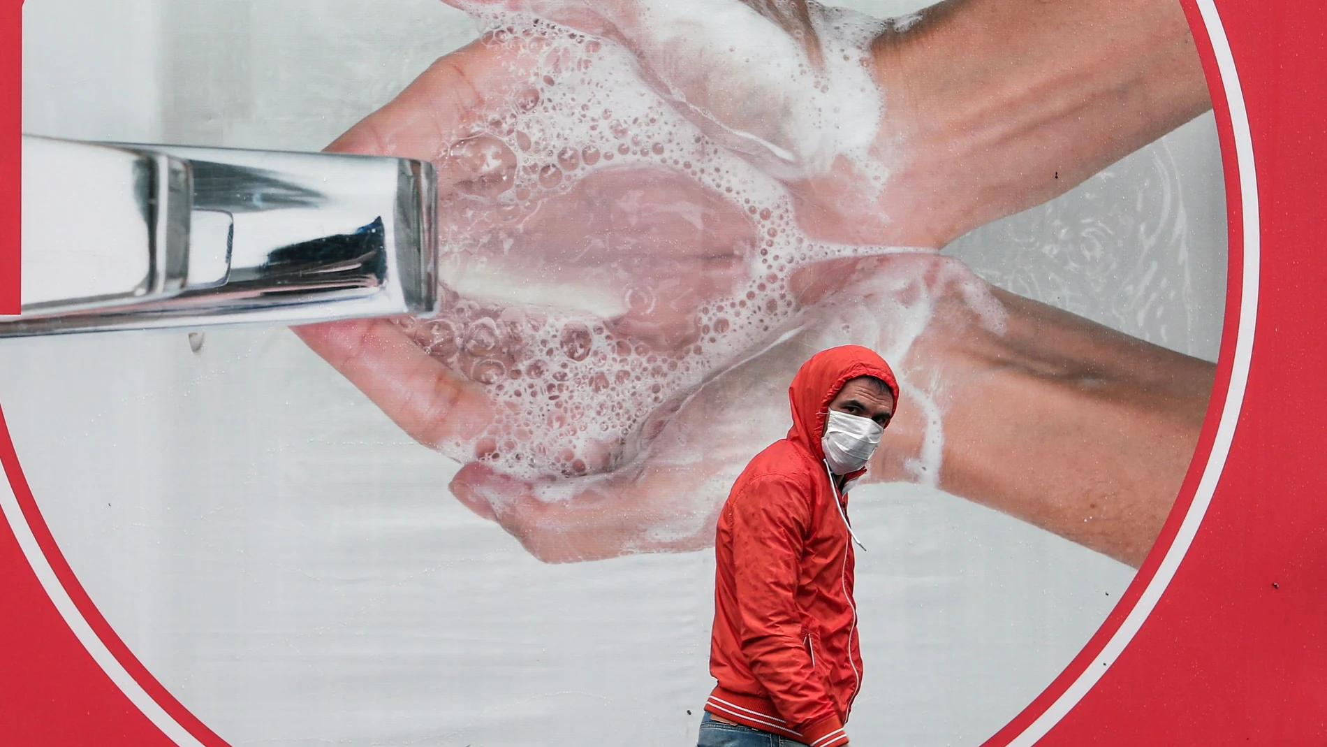 Un hombre pasa por delante de un cartel que fomenta la higiene de manos en Turquía