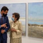 El presidente andaluz, Juanma Moreno, y la pintora Carmen Laffón, conversan durante la inauguración de la muestra "La Sal", en el Centro Andaluz de Arte Contemporáneo de Sevilla