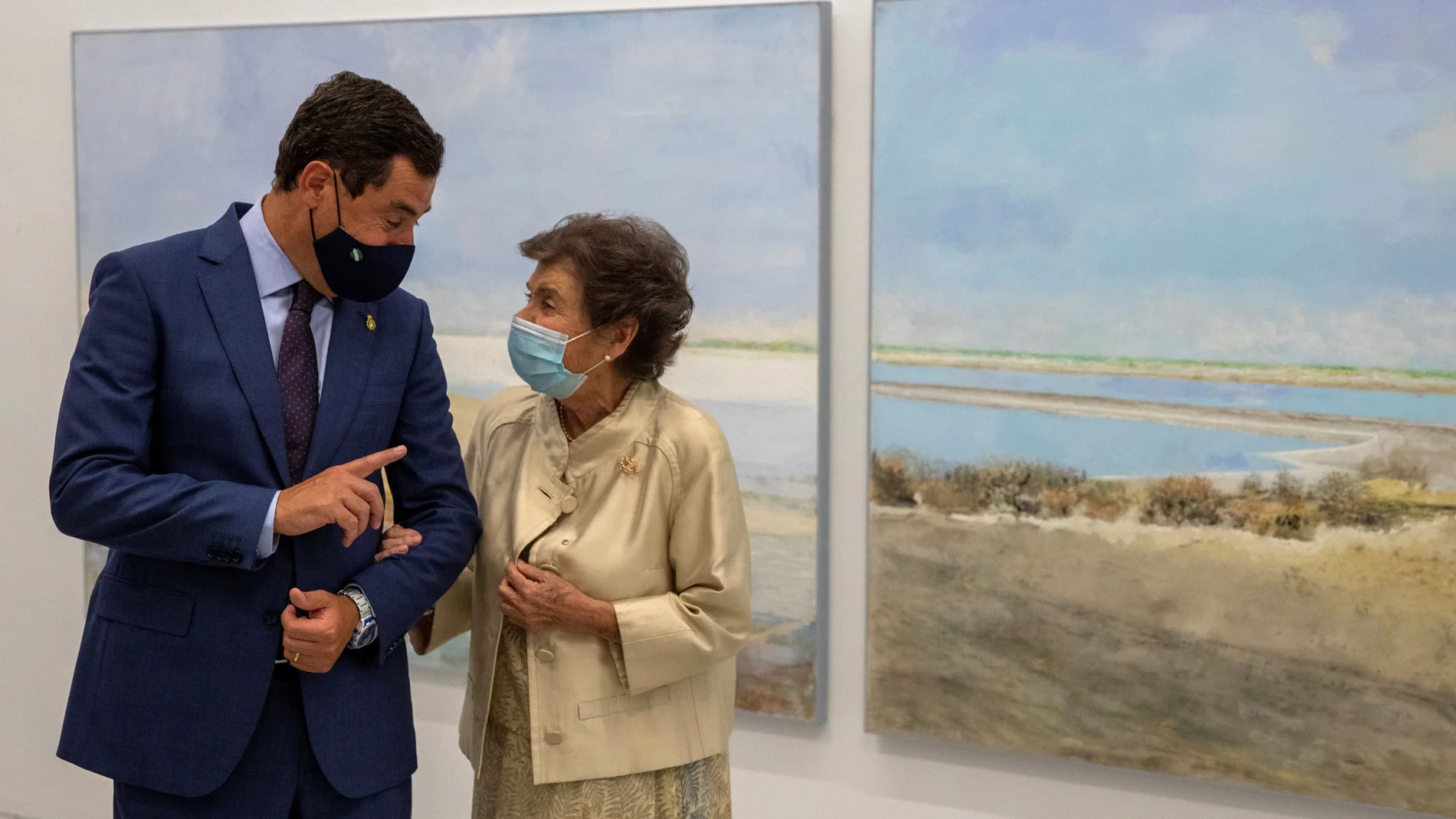 El presidente andaluz, Juanma Moreno, y la pintora Carmen Laffón, conversan durante la inauguración de la muestra "La Sal", en el Centro Andaluz de Arte Contemporáneo de Sevilla