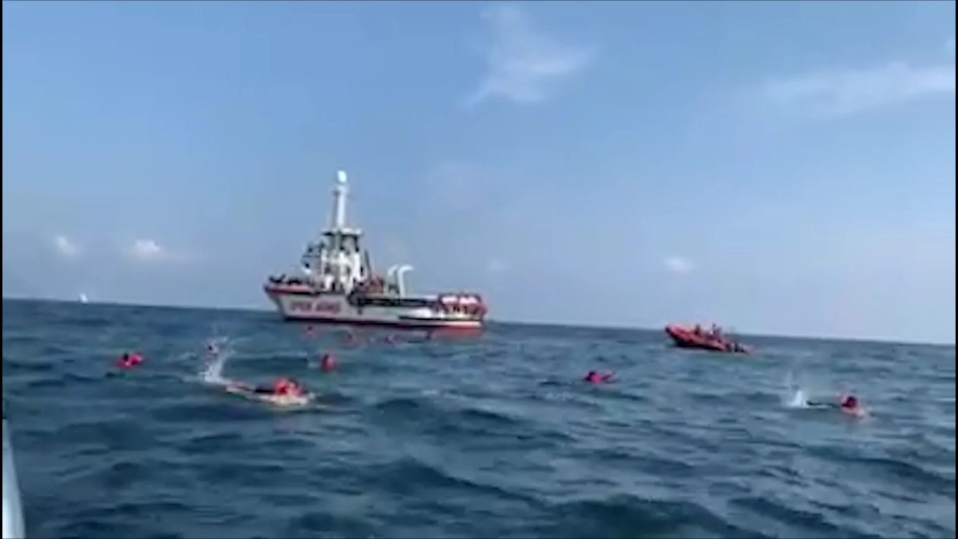 Migrants swim away from Spanish rescue ship Open Arms after more than 70 of them jumped from the ship to attempt to reach the coast, at sea near Palermo, Italy, in this still image taken from video, September 17, 2020. Open Arms/ Handout via REUTERS ATTENTION EDITORS - THIS PICTURE WAS PROVIDED BY A THIRD PARTY. BEST QUALITY AVAILABLE