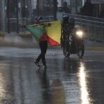 A protester holds a flag as police on motorcycles ride next to him during a protest to reject the government's economic policies, rising unemployment and the signing of an agreement with the International Monetary Fund, in Quito, Ecuador, Wednesday, Sept. 16, 2020. (AP Photo/Dolores Ochoa)