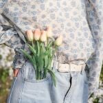En la imagen, una mujer lleva tulipanes en su bolsillo.