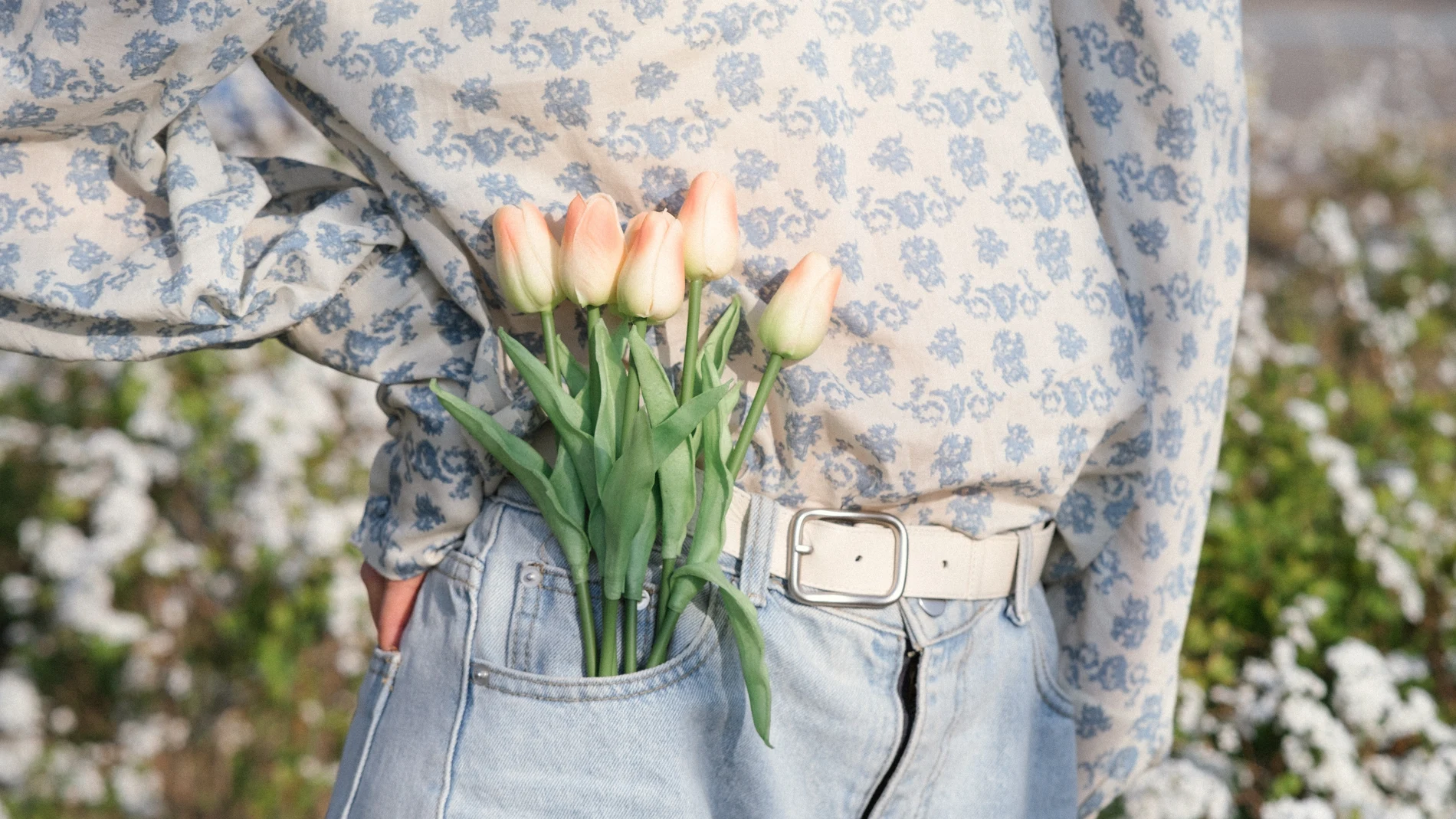 En la imagen, una mujer lleva tulipanes en su bolsillo.