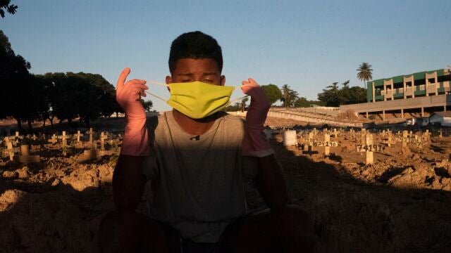 Un joven trabajador de un cementerio de Río de Janeiro trabaja en el mantenimiento y desinfección de las lápidas para evitar posibles infecciones de coronavirus.24/09/2020
