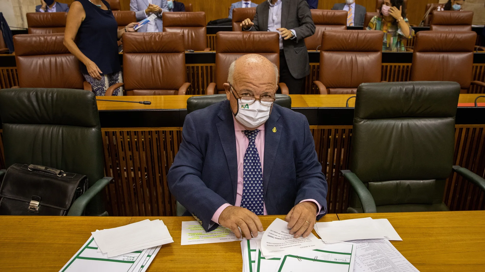 El consejero de Salud y Familias, Jesús Aguirre (c), en su escaño rodeado de informes al inicio de la sesión de control al Ejecutivo hoy en el Parlamento de Andalucía en Sevilla