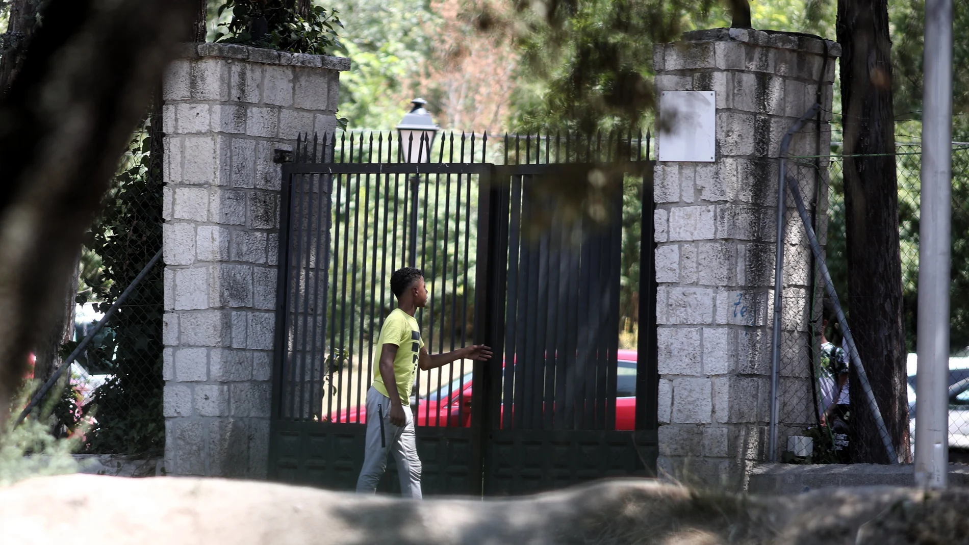 Un joven pasa por la puerta del centro de primera acogida de menores extranjeros no acompañados (menas) situado en la zona de Casa de Campo