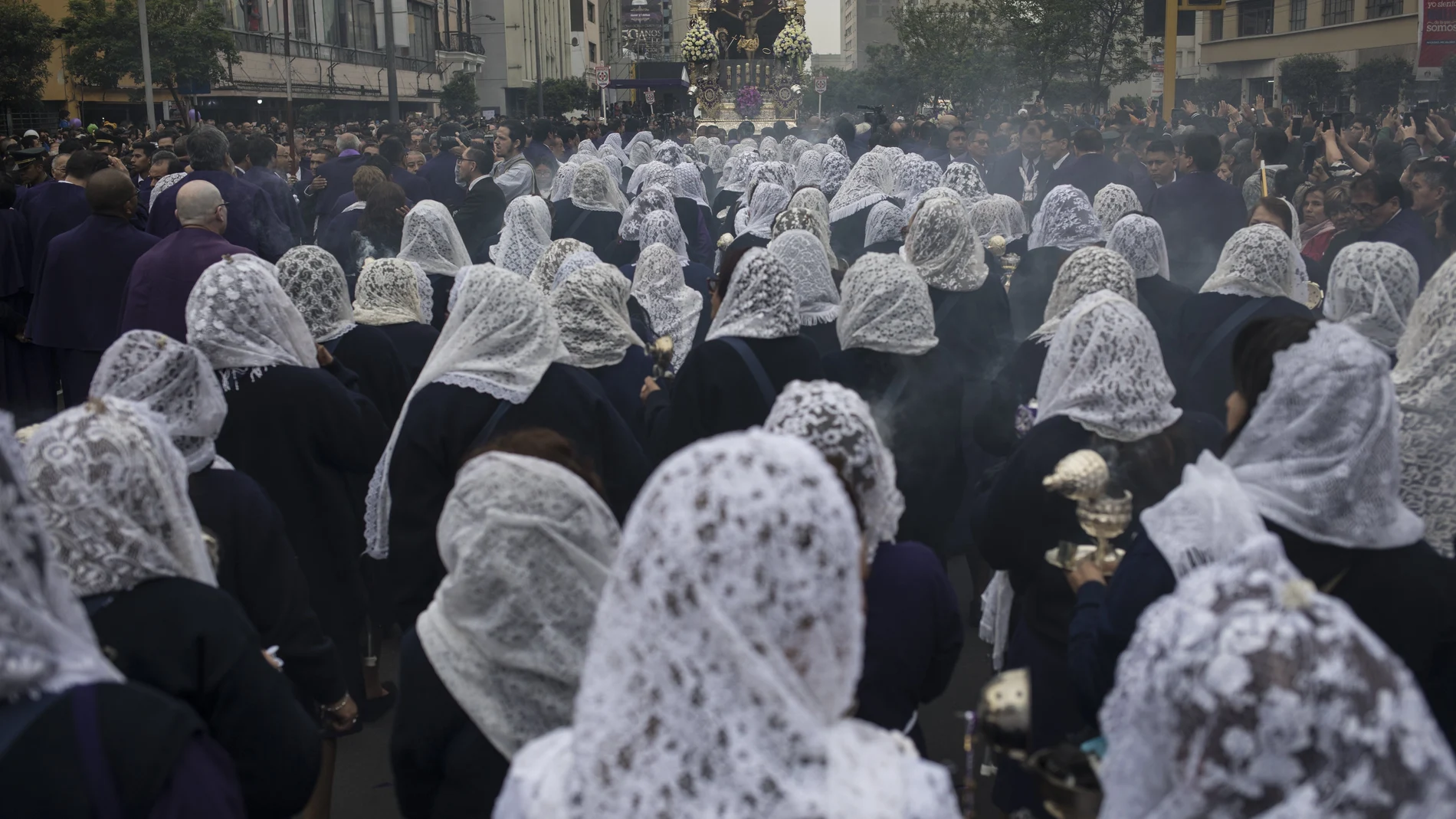 FILE - in this Oct. 18, 2019 file photo, faithful take part in a procession honoring The Lord of Miracles, the patron saint of Lima, Peru. The 2020 procession of The Lord of Miracles has been canceled as a measure to curb the spread of the new coronavirus. (AP Photo/Rodrigo Abd, File)