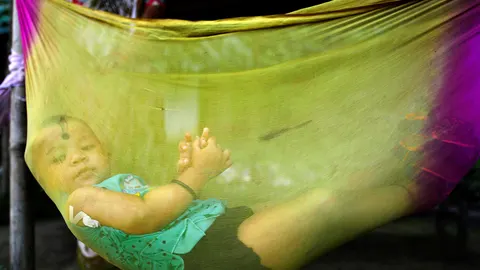 Un niño observa a través de una cuna realizada con una fina tela
