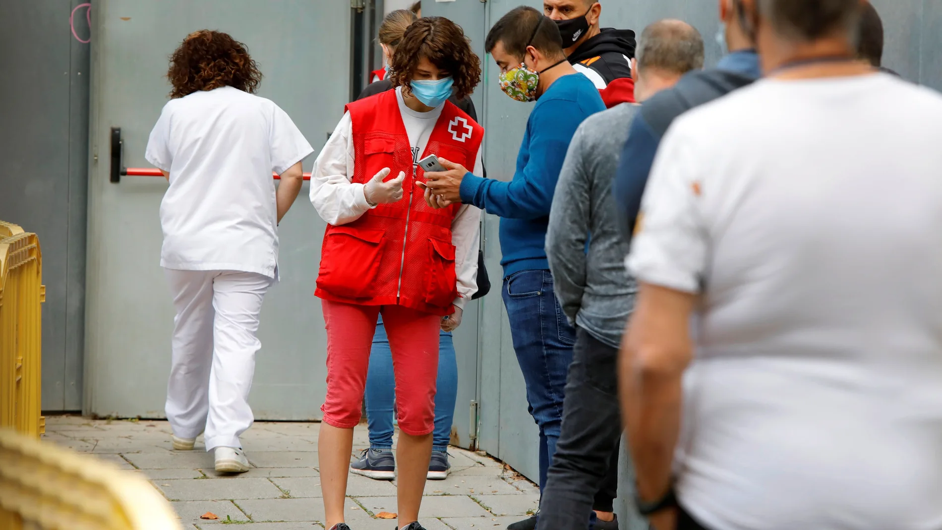 Varias personas esperan su turno para realizarse una PCR durante el cribado masivo que se lleva a cabo en la localidad de Manlleu (Barcelona), cuando el índice de riesgo de rebrote (EPG) sigue siendo muy alto en Cataluña