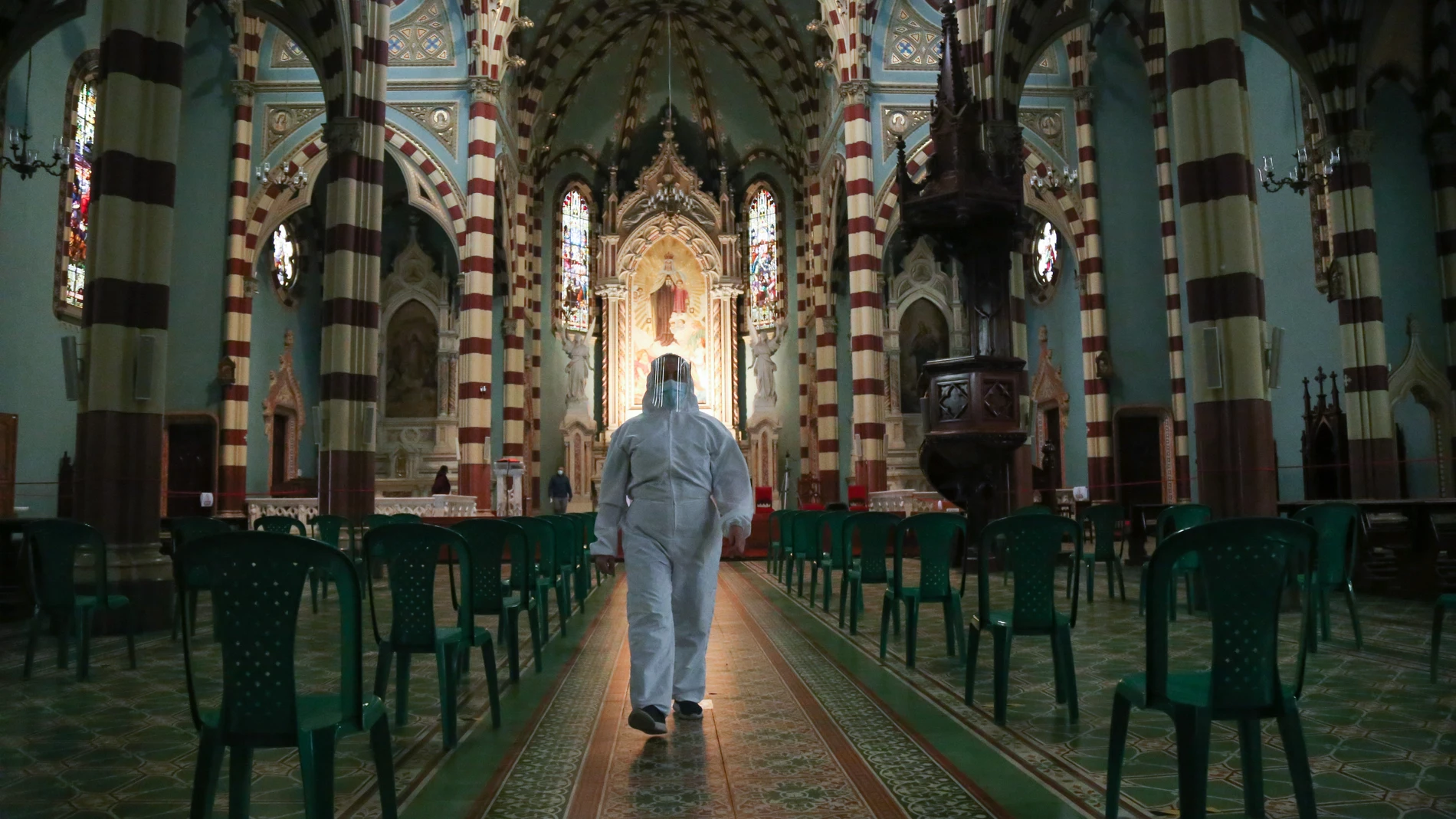 24 September 2020, Colombia, Bogota: A man in a protective suit walks through the a church after churches have been reopened to worshippers in Colombia following a long closure due to the coronavirus pandemic. Photo: Camila Diaz/colprensa/dpa24/09/2020 ONLY FOR USE IN SPAIN