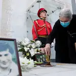 Una anciana coloca con cuidado objetos el monumento a los georgianos muertos durante el conflicto armado entre Georgia y Abjasia de 1992-1993