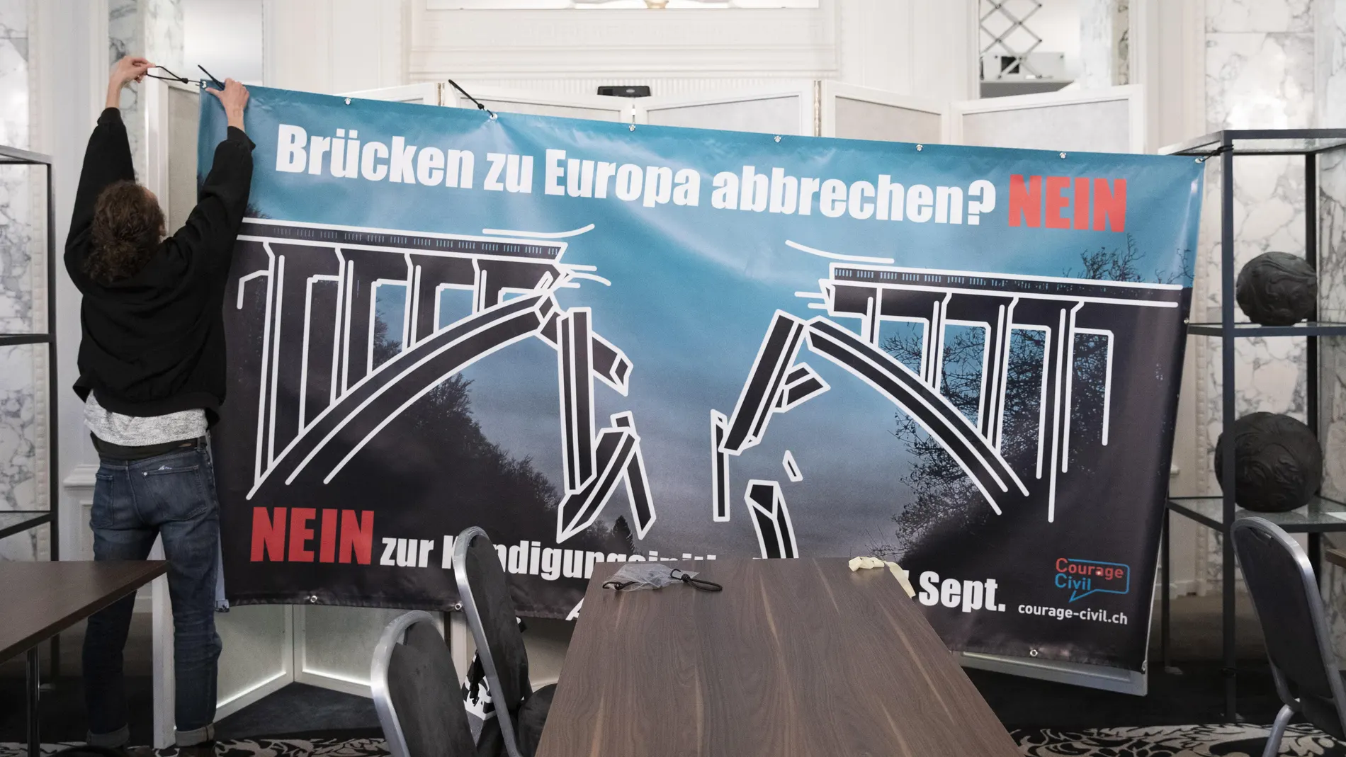 Contrarios a la limitación de la circulación de ciudadanos del espacio Schengen en Suiza colocan un cartel en el hotel Schweizerhof de Berna