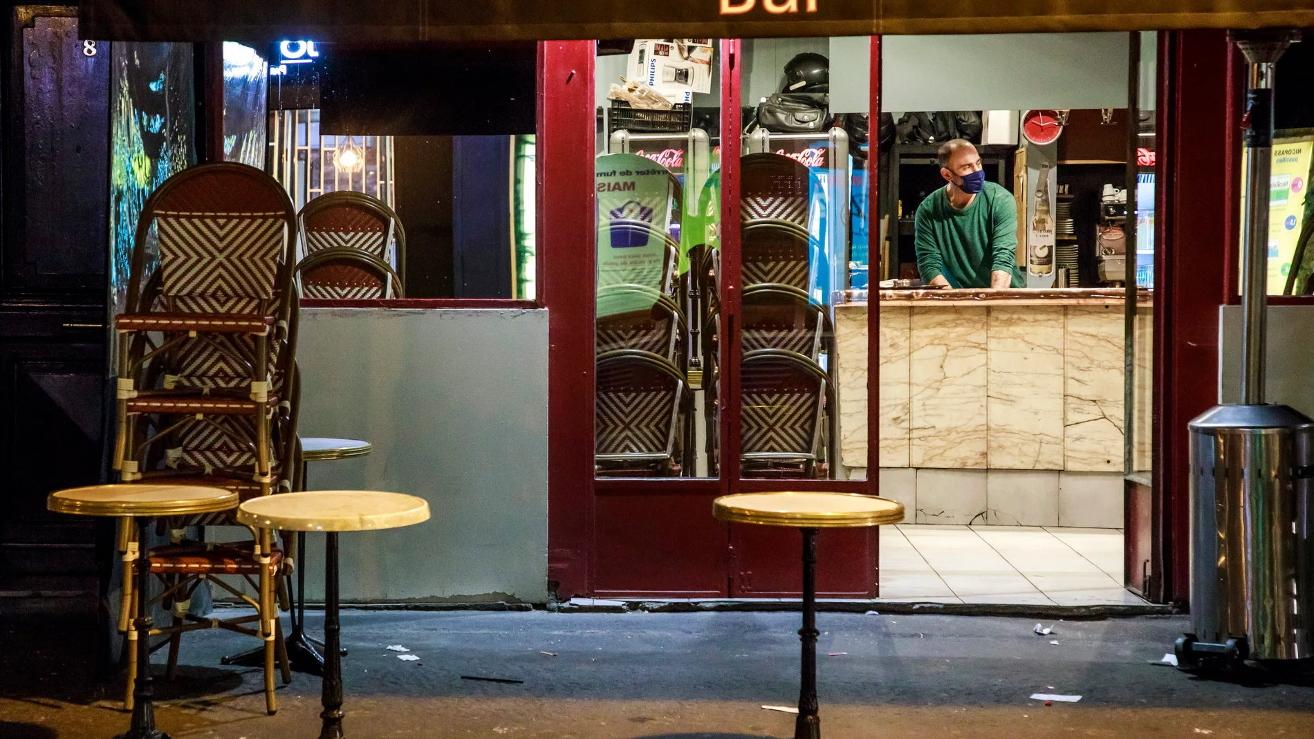Un trabajador prepara el cierre de un bar en París