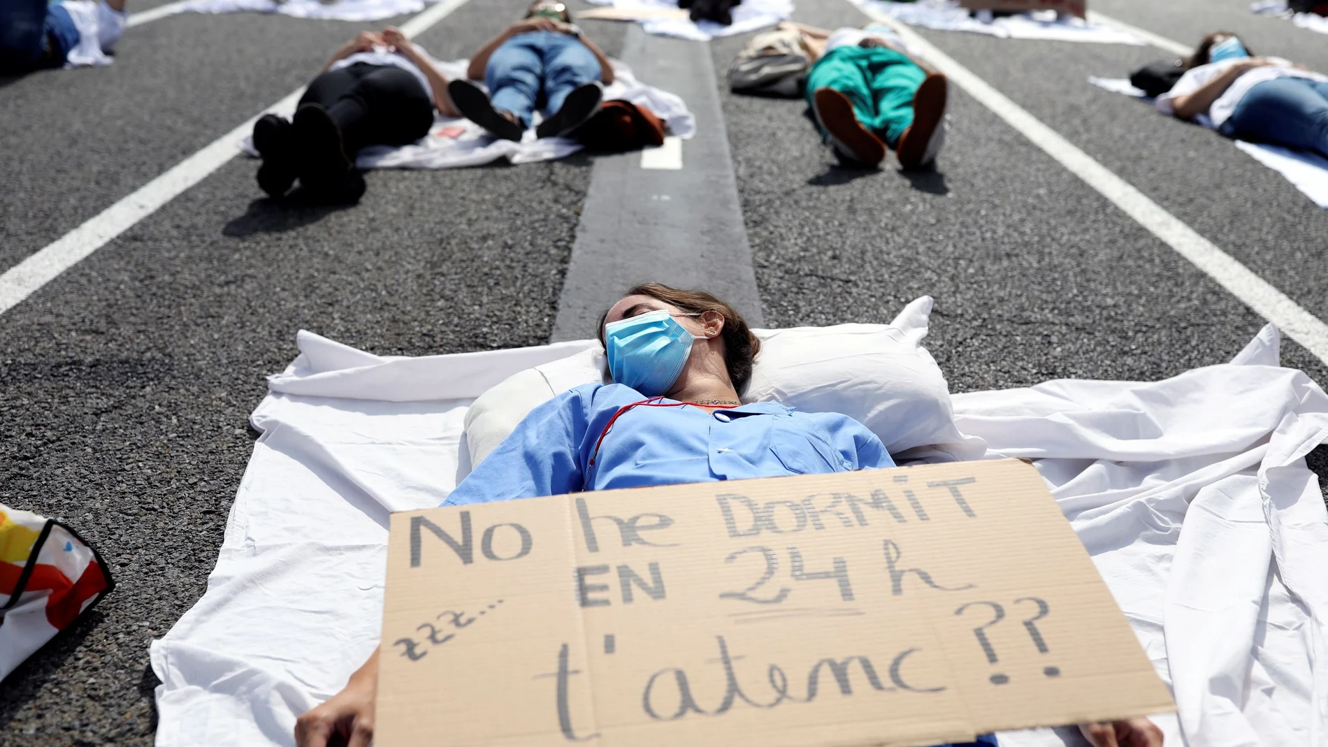 Protestas de los MIR hoy en Barcelona con un cartel que reza: "No he dormido en 24, ¿te atiendo?"