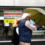 Una pareja pasa al lado de una Oficina de Empleo en Madrid