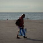 Un ciudadano se dirige hacia la playa de la Barceloneta en Barcelona, vacía de turistas. EFE/ Enric Fontcuberta