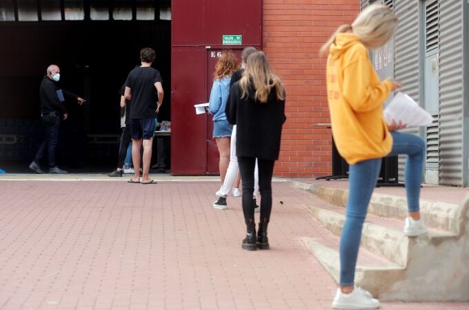 Alumnos de la Universidad Politécnica de Valencia (UPV) guardan cola en el exterior de las instalaciones del pabellón de baloncesto donde se realizan pruebas PCR a unos 700 estudiantes, tras confirmarse más de una veintena de casos positivos de covid-19 entre universitarios del campus de Vera. EFE/Kai Försterling