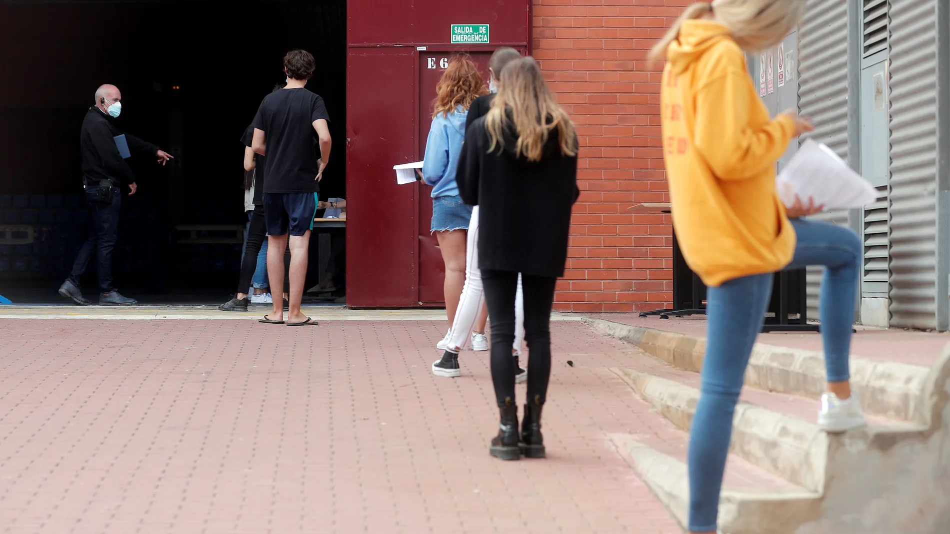 Alumnos de la Universidad Politécnica de Valencia (UPV) guardan cola en el exterior de las instalaciones del pabellón de baloncesto donde se realizan pruebas PCR a unos 700 estudiantes, tras confirmarse más de una veintena de casos positivos de covid-19 entre universitarios del campus de Vera. EFE/Kai Försterling