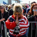 Una mujer reza sin mascarilla por la salud del presidente Trump en Staten Island, Nueva York