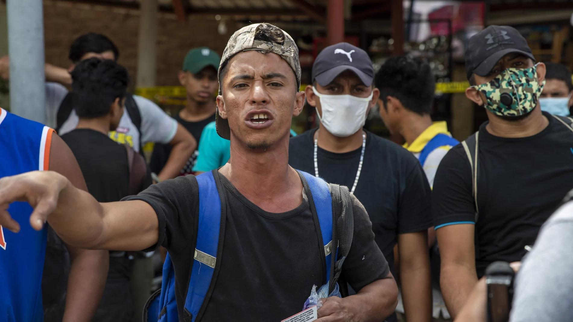 A Honduras migrant gestures as he talks with police before returning home, in Morales, Guatemala, Saturday, Oct. 3, 2020. Early Saturday, hundreds of migrants who had entered Guatemala this week without registering were being bused back to their country's border by authorities after running into a large roadblock. (AP Photo/Moises Castillo)