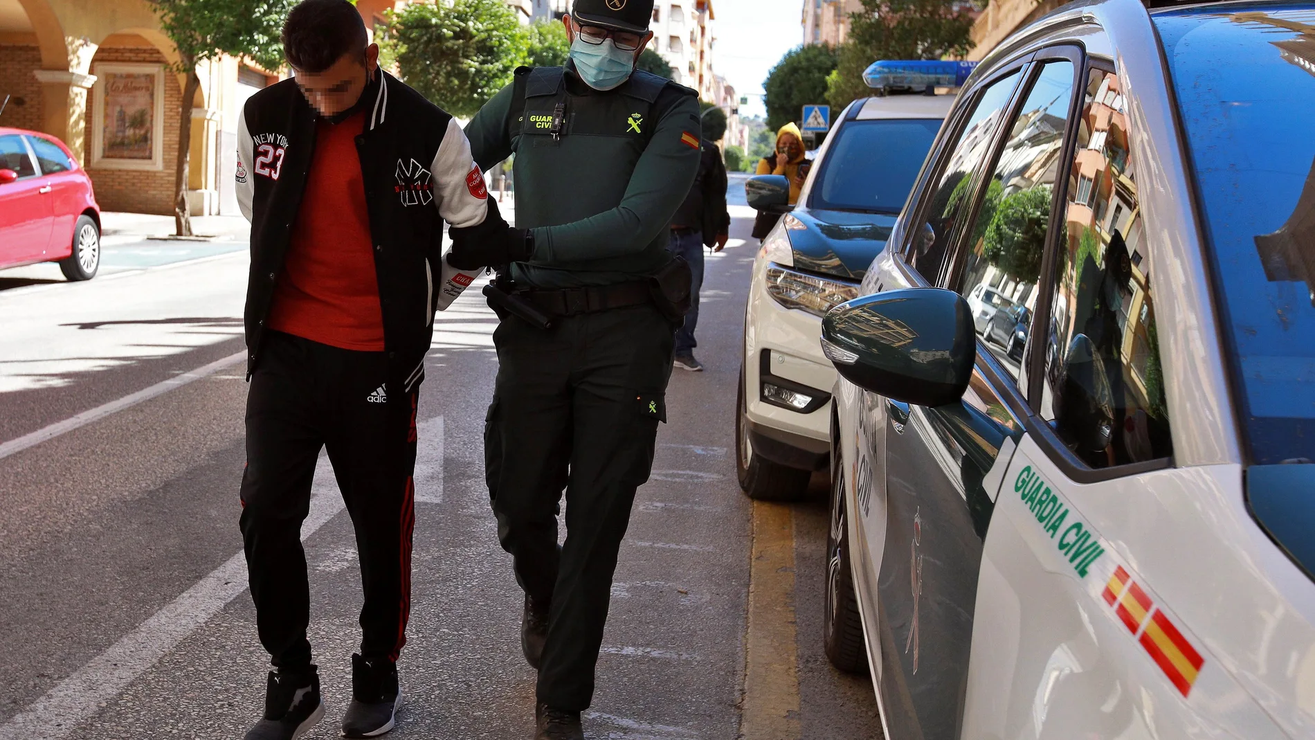 Un agente de la Guardia Civil traslada al Juzgado de Instrucción número 1 de Ontinyent, en Valencia, a uno de los diez detenidos por su supuesta participación en una violación grupal a una menor de 14 años en la localidad valenciana de l'Olleria